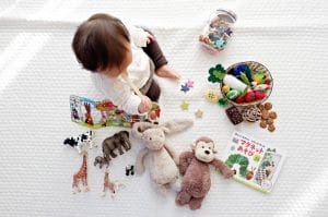 Toddler surrounded by toys - learn how to pack your child's room