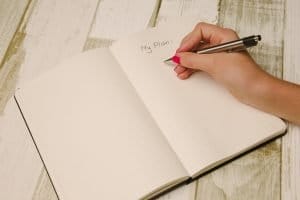 A hand writing down a plan in a notebook