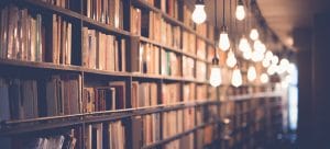 bookshelves filled with books with lightbulbs shinning in front of them