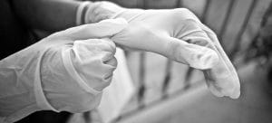 a person putting on gloves to help execute an interstate relocation during the coronavirus in the safest manner possible