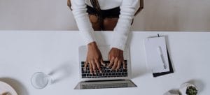 A woman typing on her laptop planning a move.