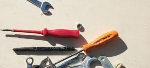 screwdrivers, wrenches and bolts on a white surface