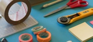 tapes, scalpels and scissors all together on a blue table