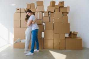 man and woman hugging in front of boxes - after moving into a new house