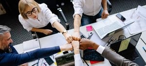 A group of people doing a fist bump because they organized a corporate relocation