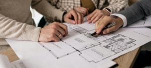 Man showing blueprint to a couple 