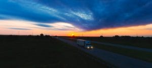 Moving truck on the road at a sunset