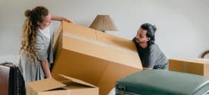 Couple carrying large moving box