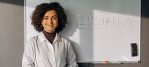 a woman standing near a white board presenting about the real cost of a diy move