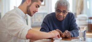 Two people pack medicines before moving a senior home